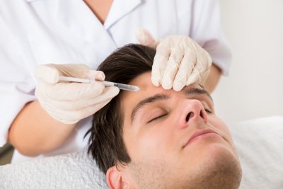 Young Man Having Botox Treatment At Beauty Clinic