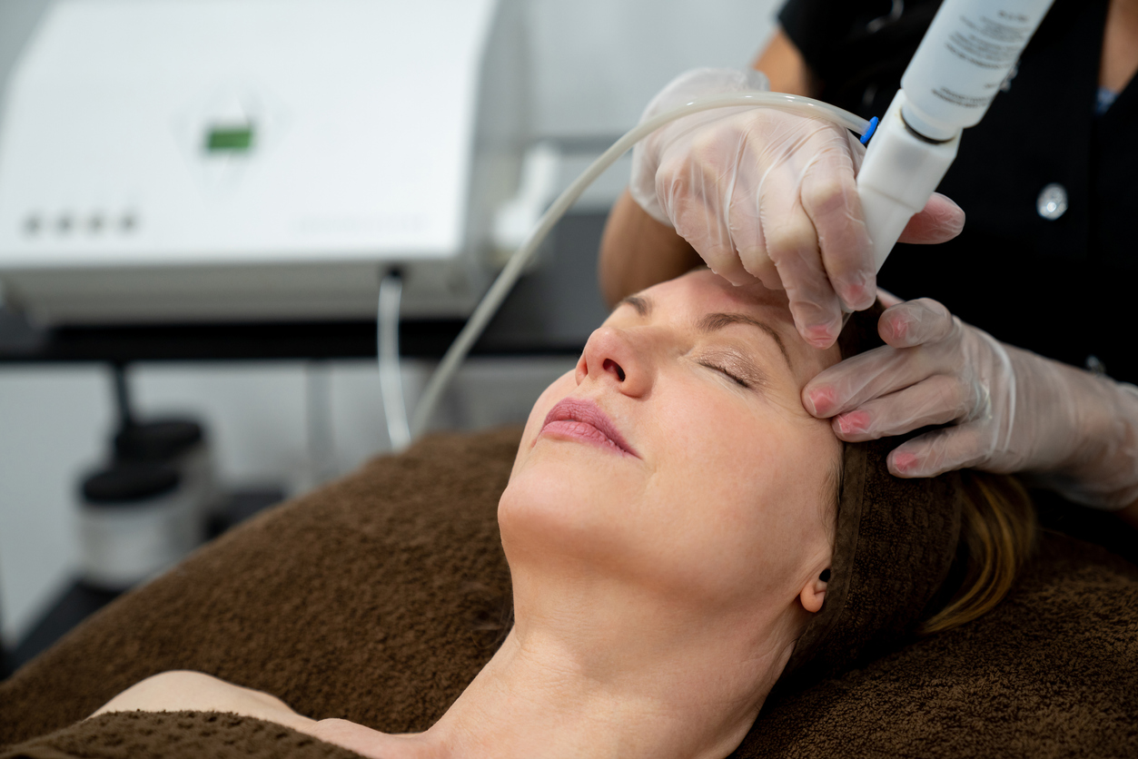 woman receiving a hydra facial by a specialist