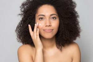 woman pulling cream product on her cheek